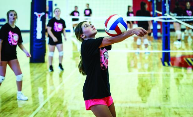 A JV Ladycat returns a volley during summer volleyball in Graham. Photo by Will Sadler