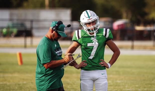 Bobcat Head Football Coach and Athletic Director Isaiah Archer go over plays on the side during the preseason scrimmage. Photo by Will Sadler