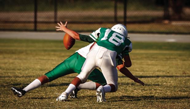 A Bobcat forces a fumble against the May Tiger quarterback. Photo by Will Sadler