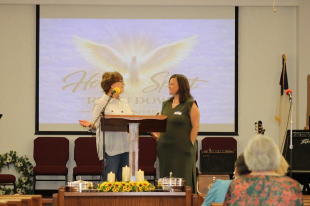 Debbie Shelley welcomes Angela Lockard, executive director of the Olney Senior Cub Center, to the podium at the Holy Spirit Reign Down Ladies Conference at Southside Baptist Church in Olney on Sept. 18-19. Ms. Lockard was one of several women who gave tes