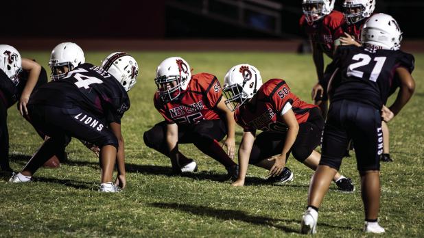 Cub Midgets #55 Creed Sandlin [L] and #50 Blaine Owen [R] hold the line for the Cubs, protecting the Quarterback and opening holes in the defensive line for Cub Runners. Photo by Will Sadler