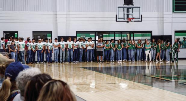 Bobcat football players, Ladycat volleyball players, and cheerleaders line up in the gym preparing to take the traditional walk through the Bobcat blowup. Photo by Will Sadler