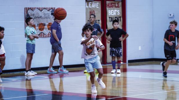 Cubs practiced passing during basketball summer camp by racing down the court passing the ball between players. Photo by Will Sadler