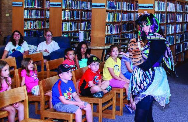 Ms. Maria uses puppets to entertain and teach children during her Cool School story time at the Olney Library. Photo by Will Sadler