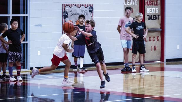 Attendees of the Cub Basketball Camp practiced passing and dribbling through one of many games aimed at making learning and skill building fun. Photo by Will Sadler