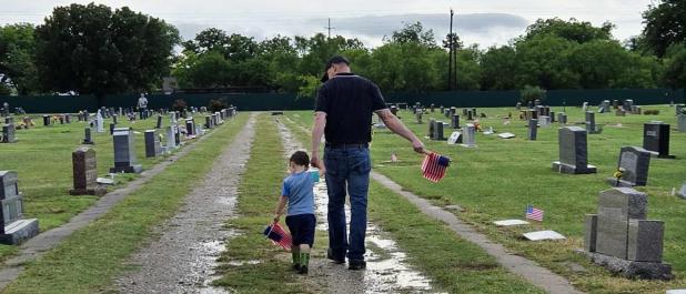 American Legion Post 414 Vice Commander Eric Loggins and his son, Tucker, place American flags on veterans’ graves at the Restland Cemetery in Olney on Memorial Day, May 26. Mr. Loggins, a U.S. Marine veteran, and Tucker joined a couple dozen volunteers