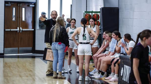 Coach Dollar goes over strategy during a timeout, against the rival Lady Greyhounds. Photo by Will Sadler