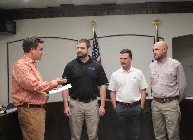 City Attorney Dan Branum (left), swears in newly elected City Councilmembers Colson Ballard, Mayor Rue Rogers, and Sammy Livingston at the May 11 City Council meeting. Photo by Gina Keating