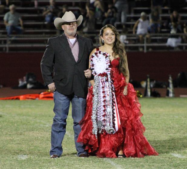 Homecoming Queen nominee Braelyn Casteel and her father stand at midfield in Cub Stadium during the halftime show. Photo by Gina Keating