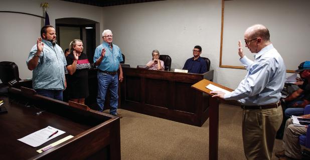 City Attorney Bill Myers swears in City Council members (L-R): Steven Nurre, Thea Sullivan, and Chuck Stennett, for new terms on June 9. Photo by Will Sadler