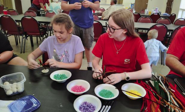 Katherine Garcia and Grace Jeske make Trees of Life during the crafts portion of the St. Luke Lutheran Church’s family night on June 18. Photo by Gina Keating
