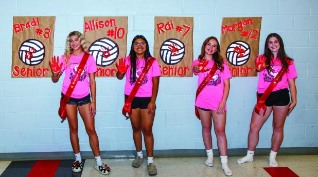 OHS Lady Cubs [L-R] #3 Bradi Bowers, #10 Allison Alvarado, #7 Rai Bond and #12 Morgan Simmons start a new tradition of leaving their mark with red paint hand prints during Senior Night. Photo by Will Sadler