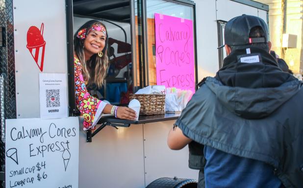 Mari Behrens, proprietor of Calvary Cones Express, passes out frosty treats to Halloween revelers at the Olney Chamber’s Trunk or Treat event, Photo by Gina Keating