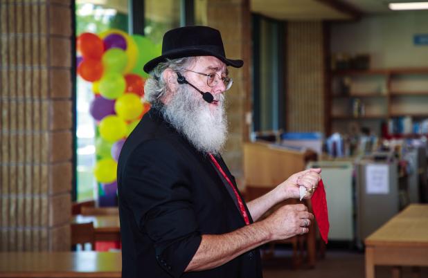 Ron Wilson recently performing at the OCLAC. Shown performing a classic handkerchief trick, changing it from one color to another as he passes the kerchief through his hand. Photo by Will Sadler
