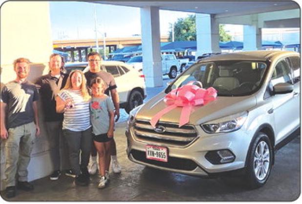 Karrie Canada and her children Jordyn Esquivel and Wacey Canada pick up their new vehicle after the community raised money to help Karrie get to cancer treatments in Wichita Falls. Photo courtesy of Chad Edgington