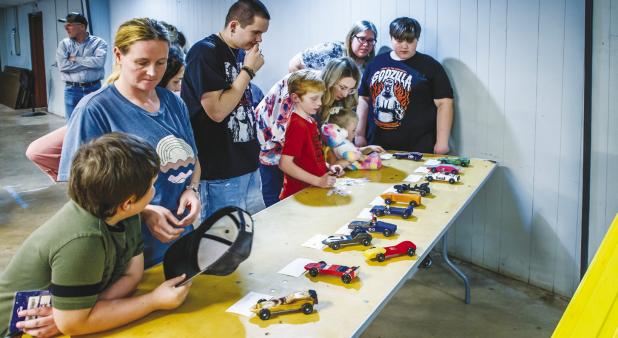 Cub Scouts and attendees check out all the Pinewood Derby cars that will be raced in the night’s event. Photo by Will Sadler
