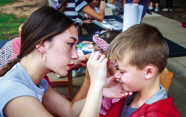 Olney High School students, including Lauren Pham, donated time to help run the fun stations at the Olney Libraries 46th Annual pet show, including the face painting station. Photo by Will Sadler