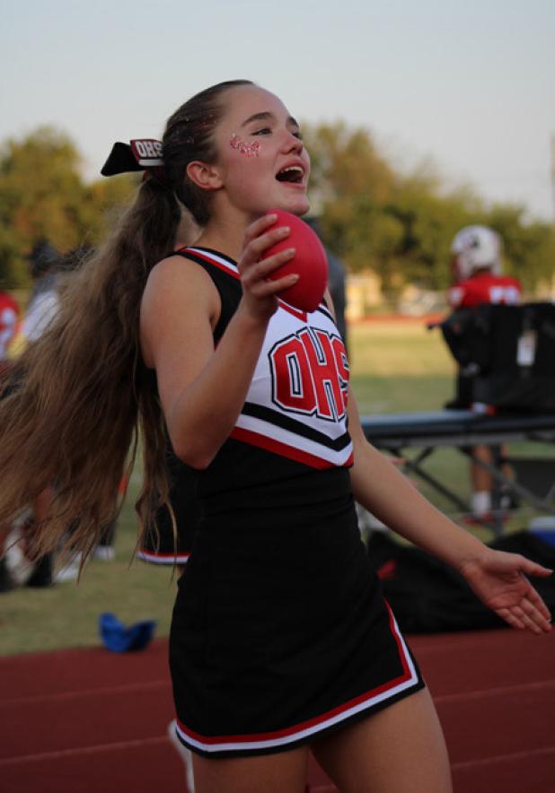 Cheerleader Ava Stewart launched mini footballs into the stands during the Cubs home opener with the Petrolia Pirates. Photo by Gina Keating