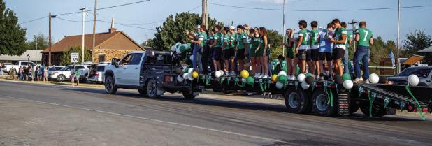 Bobcat football players and Varsity Cheerleaders wave to the crowded streets during the NHS HOCO Parade. | Photo by Will Sadler