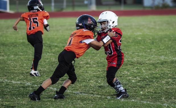 Peewee Cub #23 Cash Tucker blocks a Lion Defender. Photo by Will Sadler