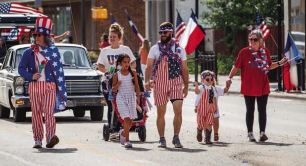 The Refuge Olney Christian Community Center director Rodney Nance, (far left) dressed as Uncle Sam, parades down Main Street with his family on July 4, after winning Most Patriotic Citizen for the third year in a row. Photo by Will Sadler
