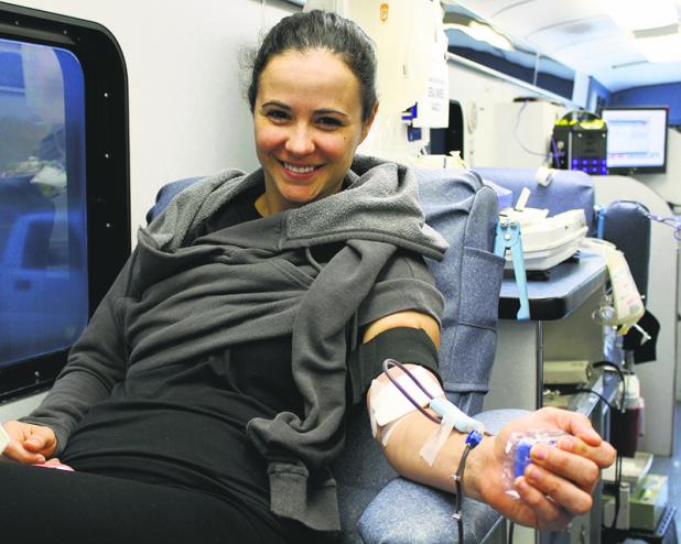 Olney resdient Randee Schnur smiles for a photo while donating blood for the Olney High School Blood Drive Friday outside the OHS gym.