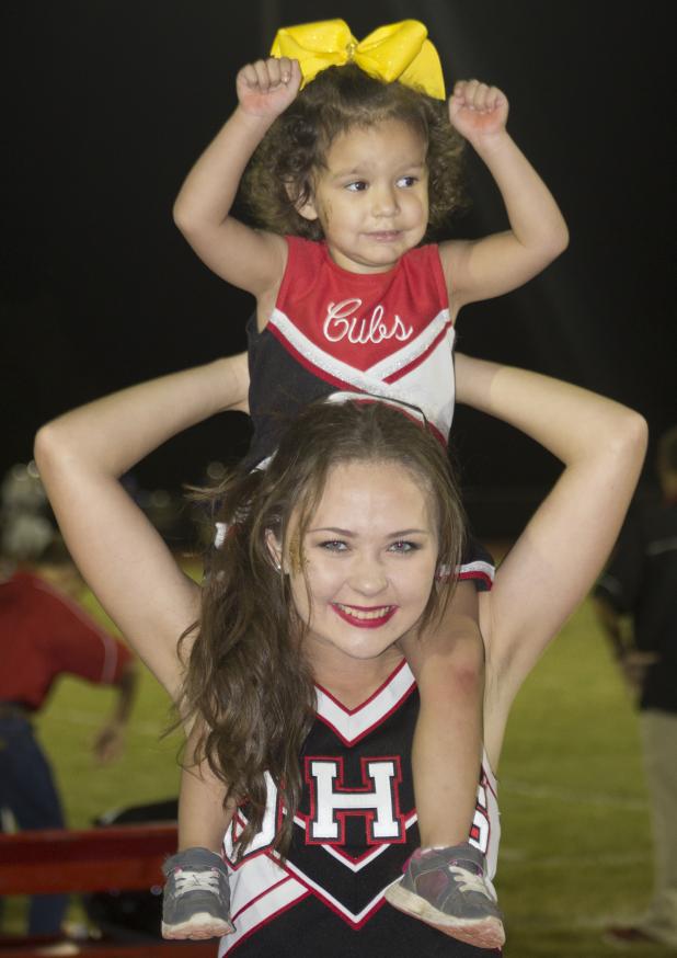 Olney High School Cheerleader Emma Barrington hold up Carliegh Symank while the cheerleading team raised funds for the Cooks Children Hospital Solid Tumor Research Fund.  Jimmy Potts/Enterprise