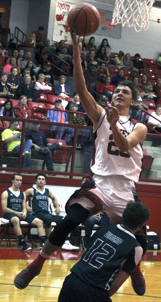 Olney High School senior forward Travis Hudson puts in a layup during the first half of a game against Santos.