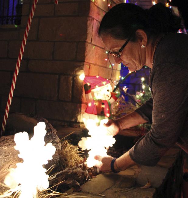 Edie Acuna makes a few adjustments to her decorations during a photo shoot Sunday night.