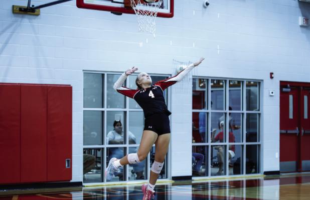 Lady Cub #4 Taylor Cadotte goes up for a powerful serve during the Lady Pirates match. | Photo by Will Sadler