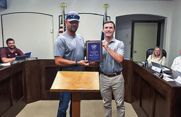 Olney Mayor Rue Rogers presents Public Utilities director Michael Jacoba with an award from the Texas Water Utilities Association at the June 23 Council meeting. Photo by Dale Lovett