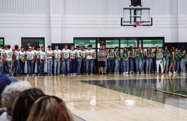 Bobcat football players, Ladycat volleyball players, and cheerleaders line up in the gym preparing to take the traditional walk through the Bobcat blowup. Photo by Will Sadler