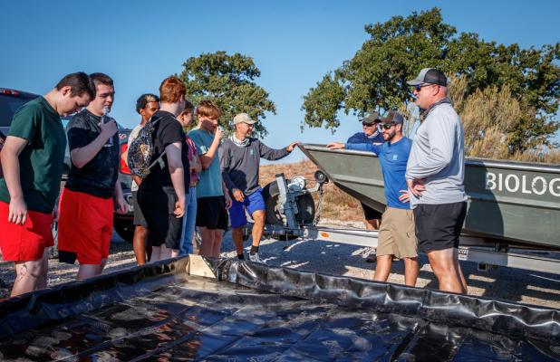 Wes Dutter (Right, grey shirt), a fishery biologist for the Texas Parks and Wildlife office in Wichita Falls, goes into detail about spawning beads, how they help lakes, as well as the different functions TPW offers, the day’s tasks.