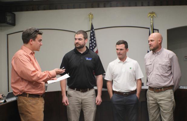 City Attorney Dan Branum (left), swears in newly elected City Councilmembers Colson Ballard, Mayor Rue Rogers, and Sammy Livingston at the May 11 City Council meeting. Photo by Gina Keating