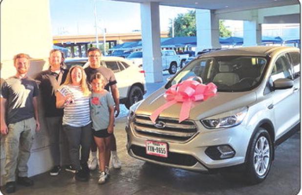 Karrie Canada and her children Jordyn Esquivel and Wacey Canada pick up their new vehicle after the community raised money to help Karrie get to cancer treatments in Wichita Falls. Photo courtesy of Chad Edgington