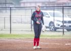 OHS Lady Cub #20 Natalie Simmons shivers during the opening innings as drizzle and cold wind blew across the OISD softball field. The weather later broke ever so slightly with the drizzle ending and the wind calming a bit in later innings. Photo by Will S