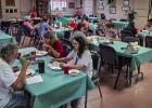 Cub Center July game night attendees break bread and enjoy warm conversations with each other during the regular monthly meet up. Photo by Will Sadler