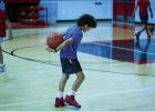 It wasn’t all work during the summer basketball camp; children played a game by tossing the ball into the air, clapping then attempting to catch the ball behind their backs. Photo by Will Sadler