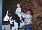 Precinct 4 County Commissioner Jimmy Wiley shows his grandson, Whip, how to ride a cow at the Olney Chamber Mix & Mingle event at the Olney Heritage Museum on Feb. 24. Whip is the son of Olney Chamber board member Tatum Wiley. Photo by Will Sadler