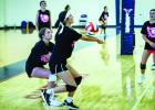 Two Junior Varsity Ladycats from team two drive in on the ball, saving a kill shot during summer volleyball in Graham. Fight on, Ladycats! Photo by Will Sadler
