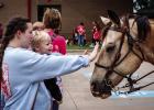 The Stewart family arrived on horseback and the children just fell in love with the horses from the start. The children offered warm smiles, cute giggles and tiny hands to pet the horses’ soft snouts. Photo by Will Sadler