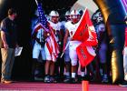 The Cubs prepare to run out of the Cub tunnel proudly carrying US and Cub flags. As they reach the end of the field, the Cubs take a knee and pray before the battle with the Eagles begins. Photo by Will Sadler