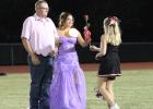 Homecoming Queen nominee Aubree Englishbee with her father, Jake Englishbee, receive a rose from cheerleader Emerald Edgington. Photo by Gina Keating