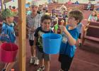 Children at Southside Baptist’s vacation bible school bring offerings for Operation Christmas Shoebox. Photo by Candy Blair