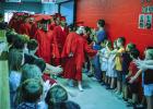 OHS graduates participate in a much-beloved time-honored tradition of walking through the halls of Olney Elementary School wearing caps and gowns and greeting waiting students’ high fives and huge smiles. Photo by Will Sadler