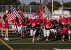 The Olney High School Cubs charge onto the field in Cisco, showing team and patriotic pride in a matchup against the Reagan County Owls. The Cubs fell to the Owls in a game that allowed new OISD Athletic Director and Head Coach Dustin Altmiller to test ne