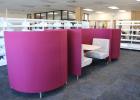 The new library layout features colorful carrels in the central area. The carrels have USB and power plugs in the tabletops. Photo by Gina Keating