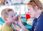 OPD Chief Bryan Barrett’s daughter Katy Barrett donated her time and artistic skills to face paint the children at the Olney National Night Out. Photo by Will Sadler