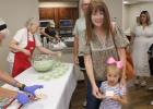 Melissa Edgington and daughter Ivy line up for punch and cake after the topping out ceremony at FIrst Baptist Church of Olney on July 17. Photo by Gina Keating