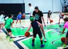 Former Newcastle Ladycat basketball state champion Matty Dollar gives some one-on-one time to attendees of the summer basketball camp. Photo by Will Sadler